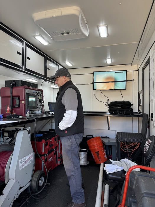 A technician operating a video inspection monitor inside the ClogBusters Truck.