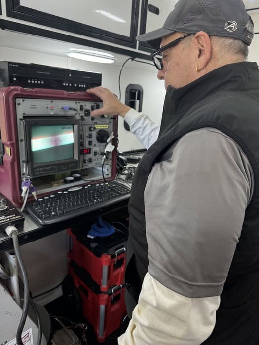 A technician operating a video inspection monitor